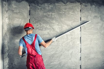 industrial worker with plastering tools renovating a house. builder worker plastering facade industrial building with leveler industrial worker with plastering tools renovating a house. builder worker plastering facade industrial building with leveler